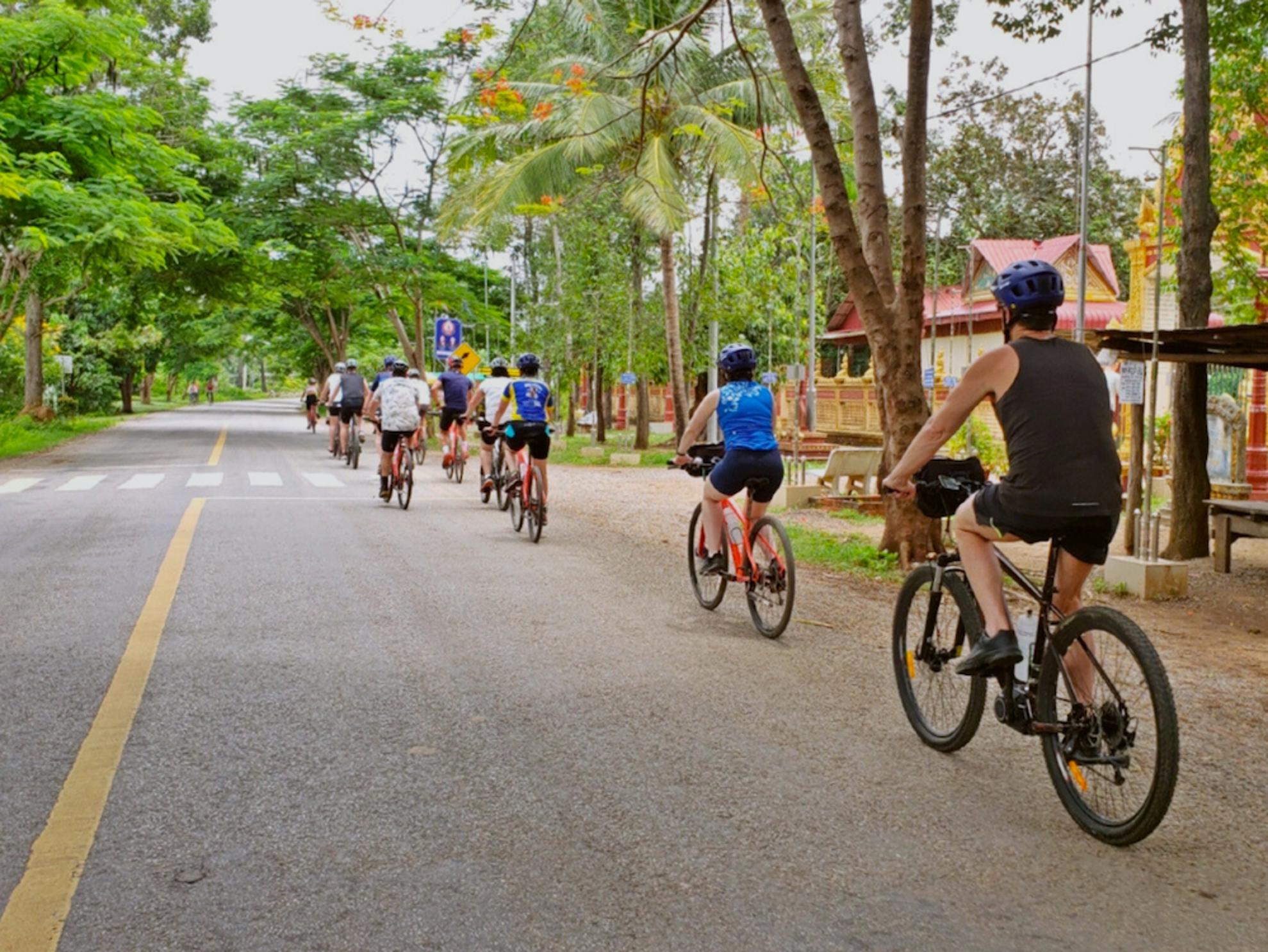 Cyclists ride through village Battambang